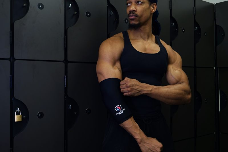Athlete in a locker room adjusting the Elemental Armor Elbow Sleeve