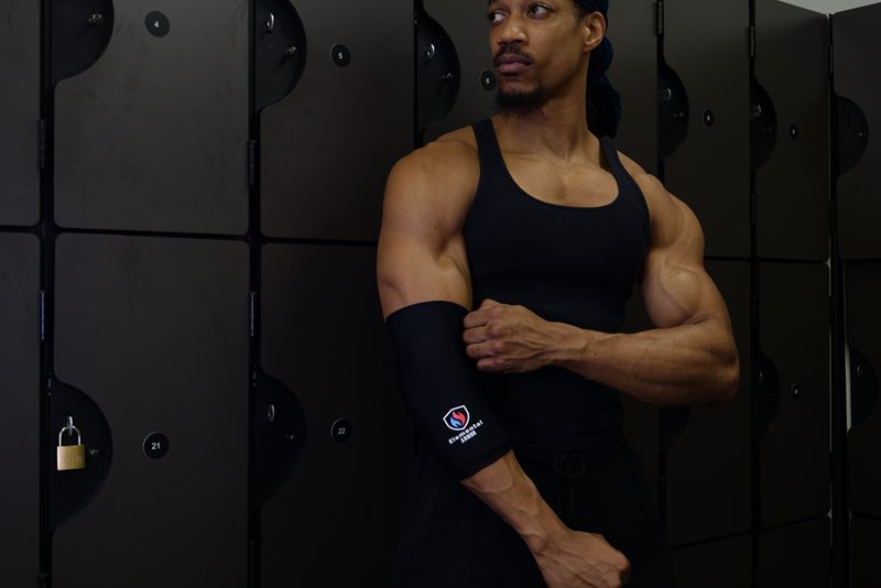 Athlete in a locker room adjusting an Elemental Armor Elbow Sleeve