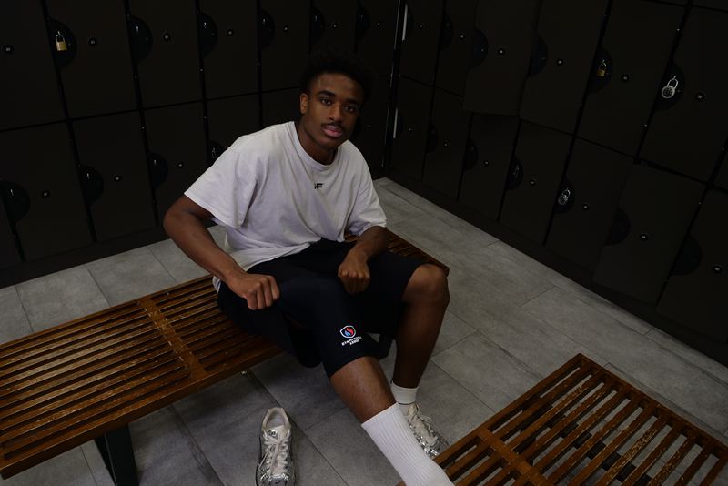 Athlete resting on a locker room bench wearing the Elemental Armor Knee Sleeve