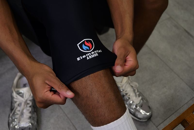 Hands pulling the Knee Sleeve into place over the knee