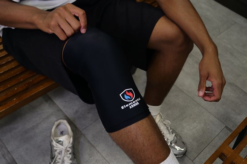 Athlete fitting the Knee Sleeve in a locker room